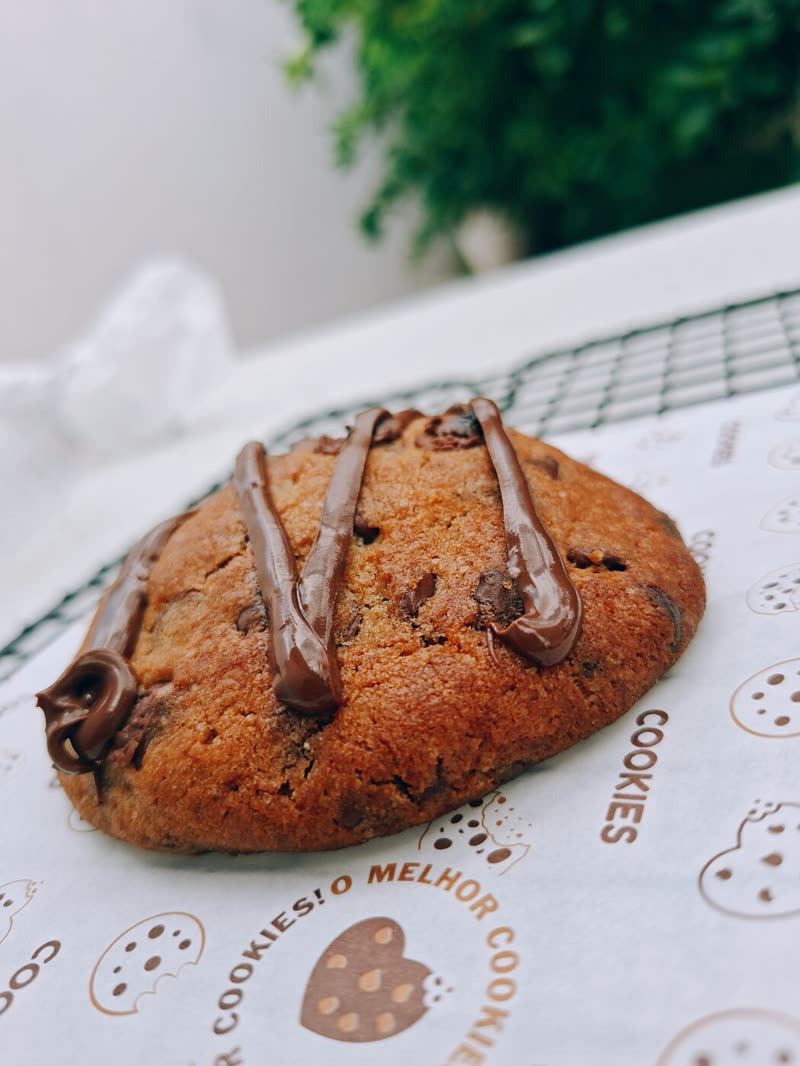 Cookie com fios de chocolate sobre papel de cookies